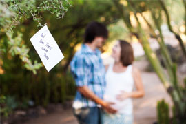 Expectant parents with And Then There Were Three sign