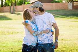 expectant parents covered in blue paint to show they are having a boy