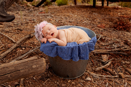 Newborn baby girl outdoors in a bucket