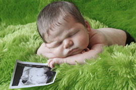 Newborn boy with his ultrasound picture