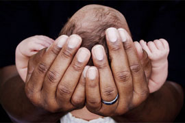close up of newborn boy in dad's hands