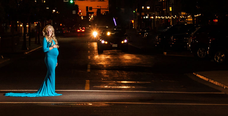 Pregnant woman in blue dress in downtown Phoenix, Arizona at sunset